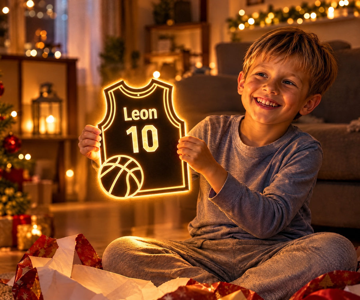 Un garçon déballe son miroir MAILLUMI en forme de maillot de basket lumineux, avec son prénom et son numéro, le matin de Noël